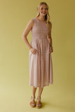 Woman wearing a pink checkered dress against a yellow background