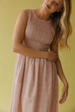 Woman wearing a pink checkered dress against a yellow background