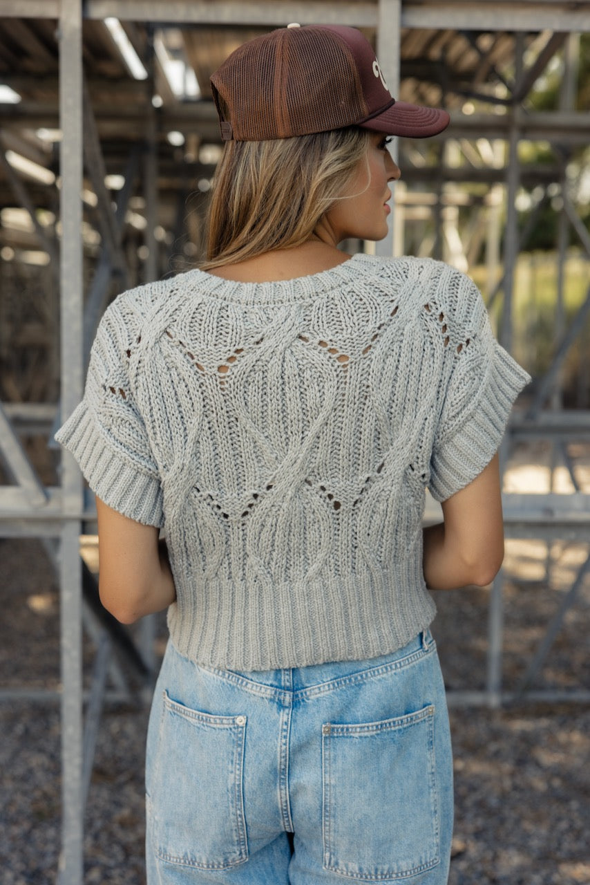 a woman wearing a sweater and jeans