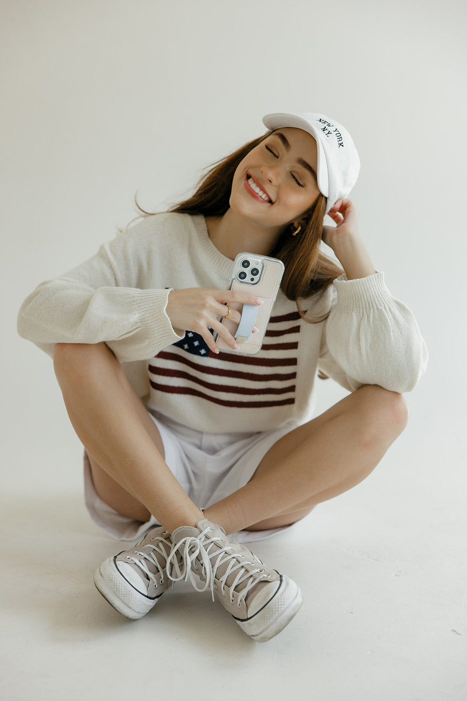 a woman sitting on the floor holding a phone