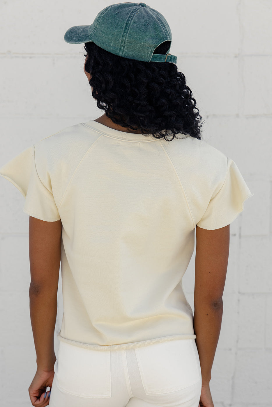 a woman with curly hair wearing a white shirt