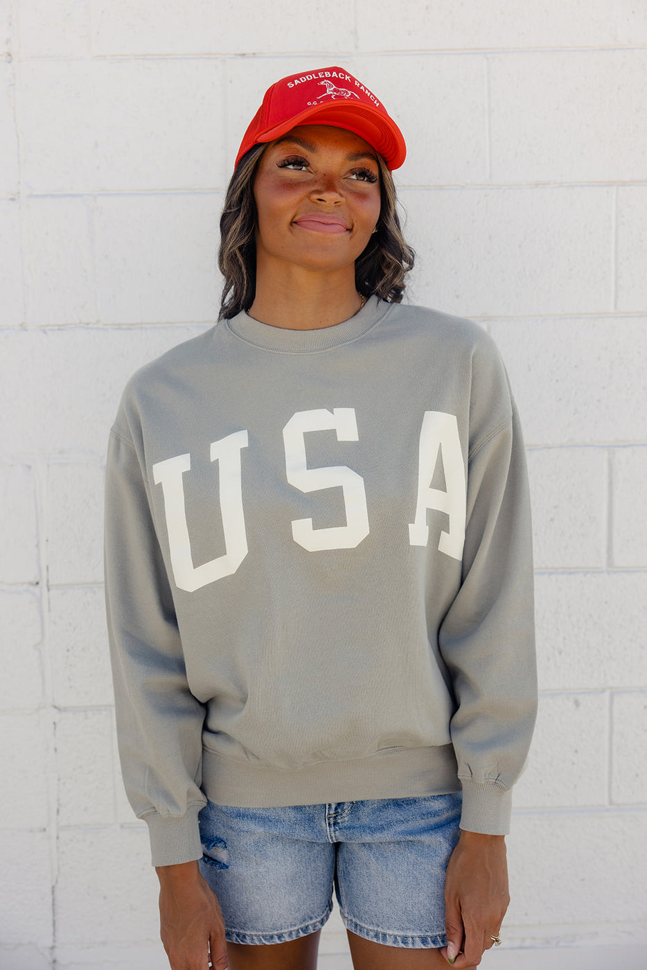 a woman wearing a red hat and a grey sweatshirt