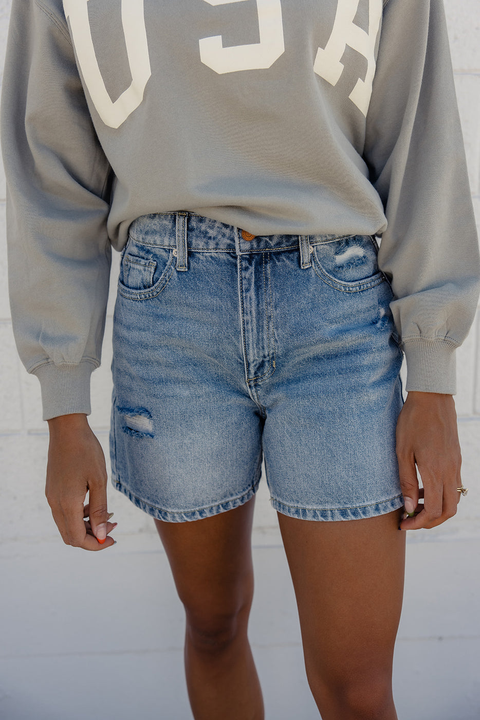 a person wearing blue jean shorts