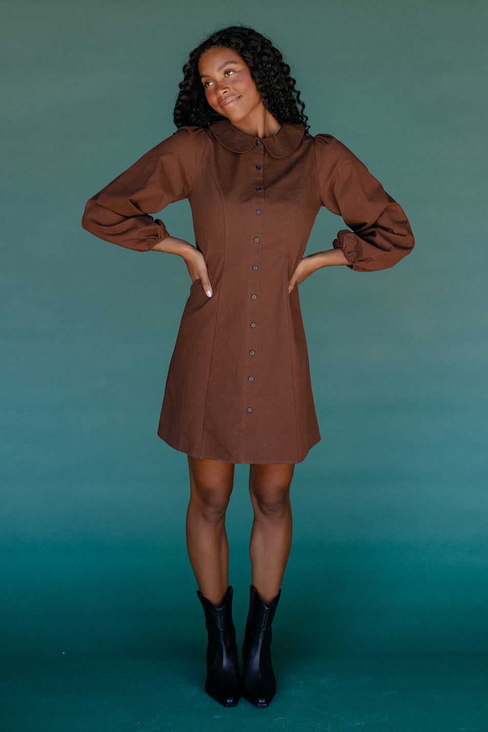 Woman wearing a brown dress against a teal background