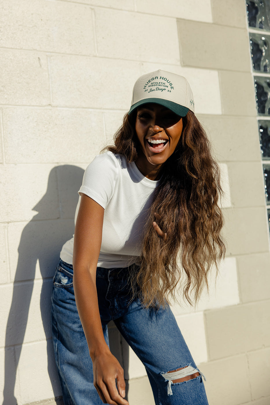 a woman wearing a hat and laughing