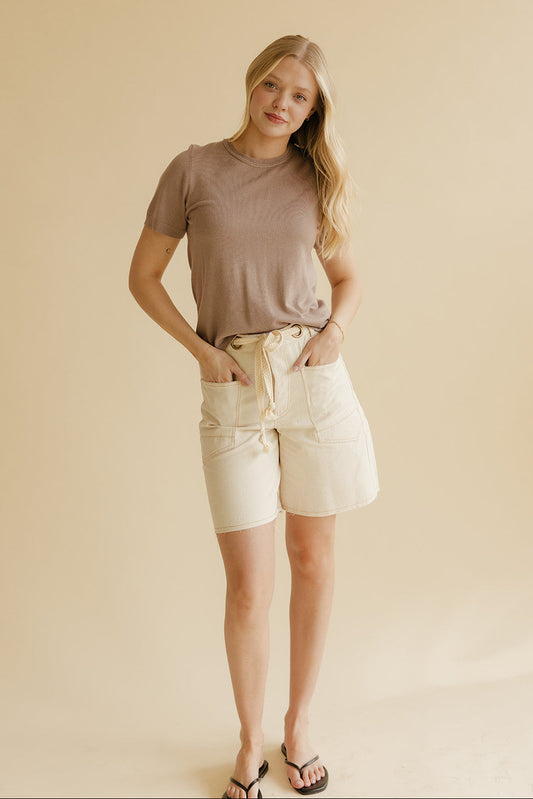 Woman wearing ivory shorts and flip flops