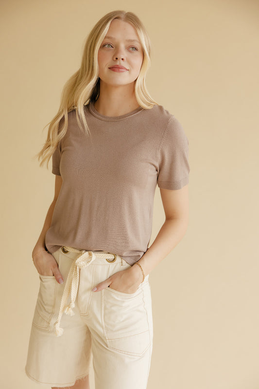 Woman wearing a brown tee and ivory shorts on a yellow background