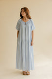 Woman wearing a light blue dress against a beige background