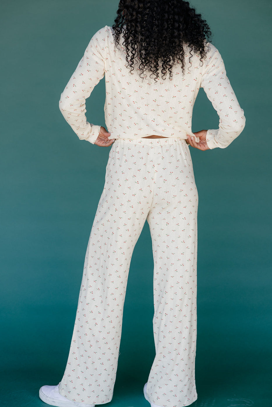 Person wearing a white textured outfit against a teal background