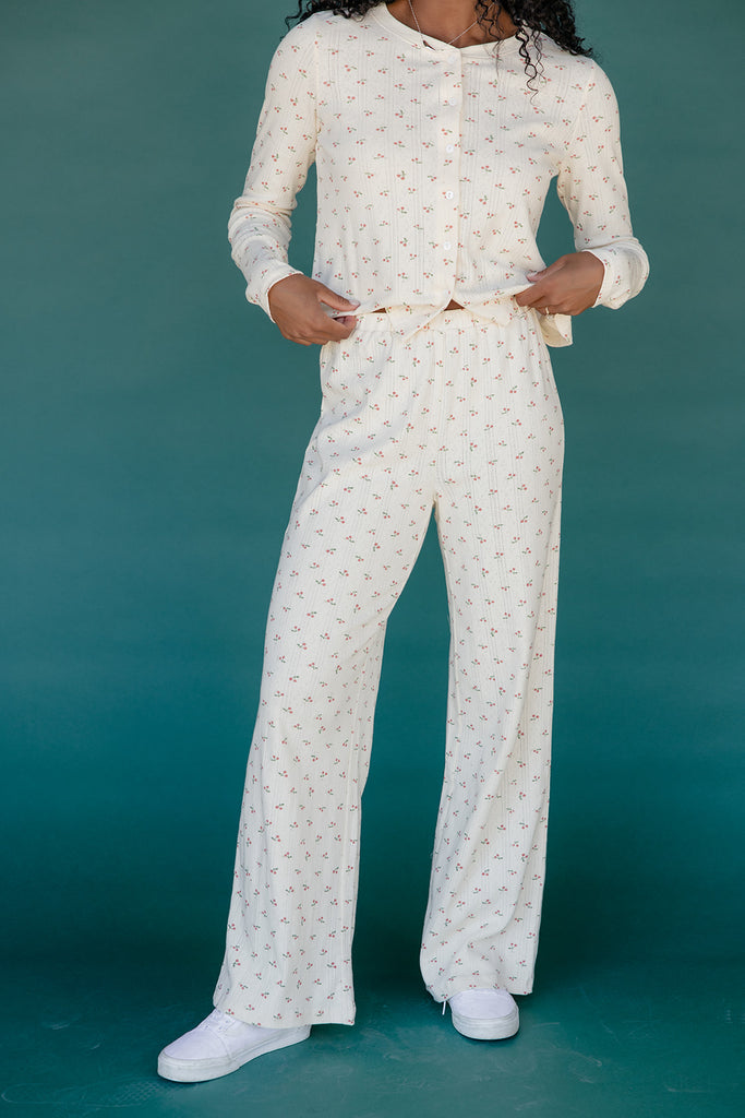 Person wearing a white patterned outfit on a teal background