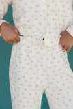 White pajama set with floral pattern on a teal background
