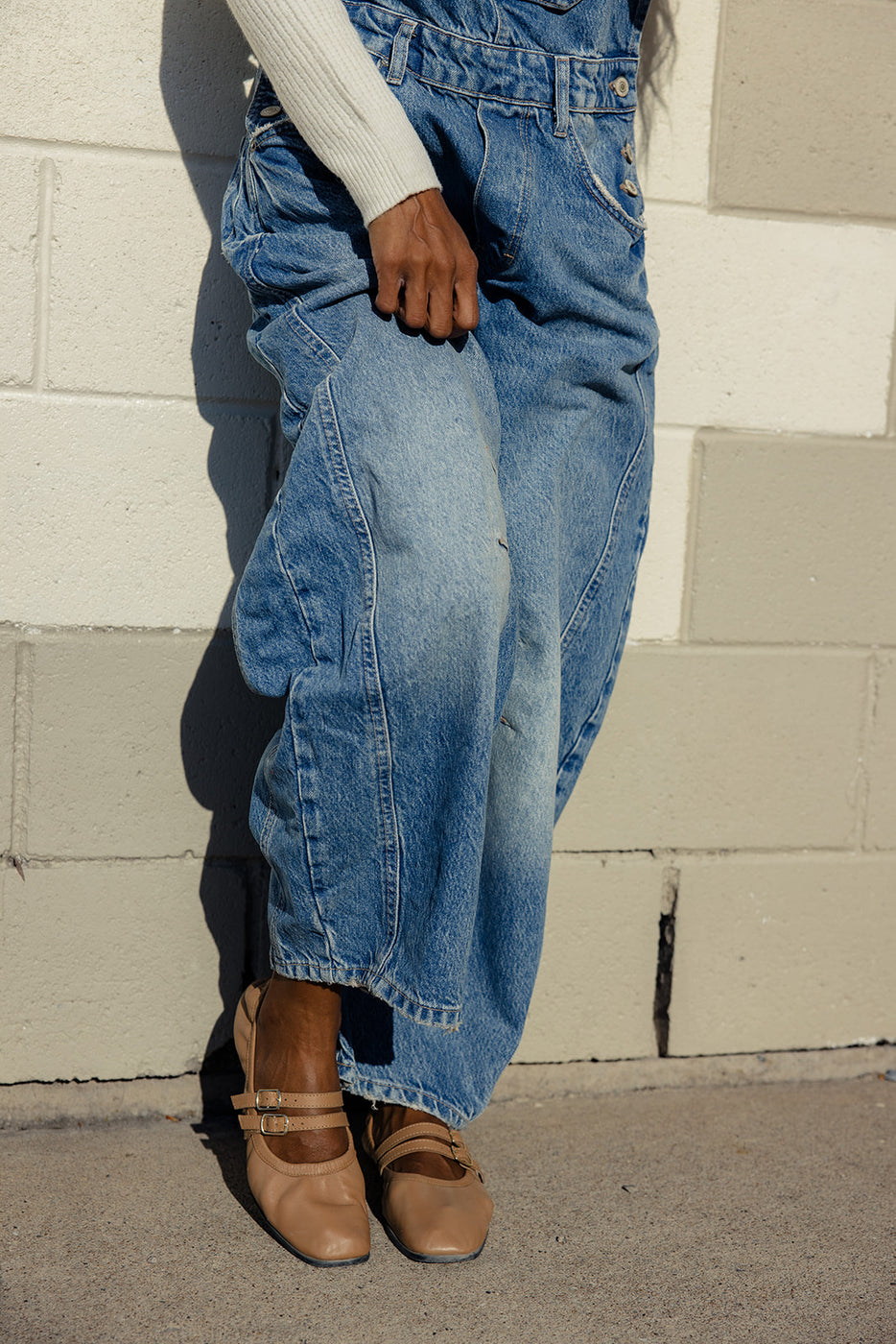 a person wearing blue jeans and sandals