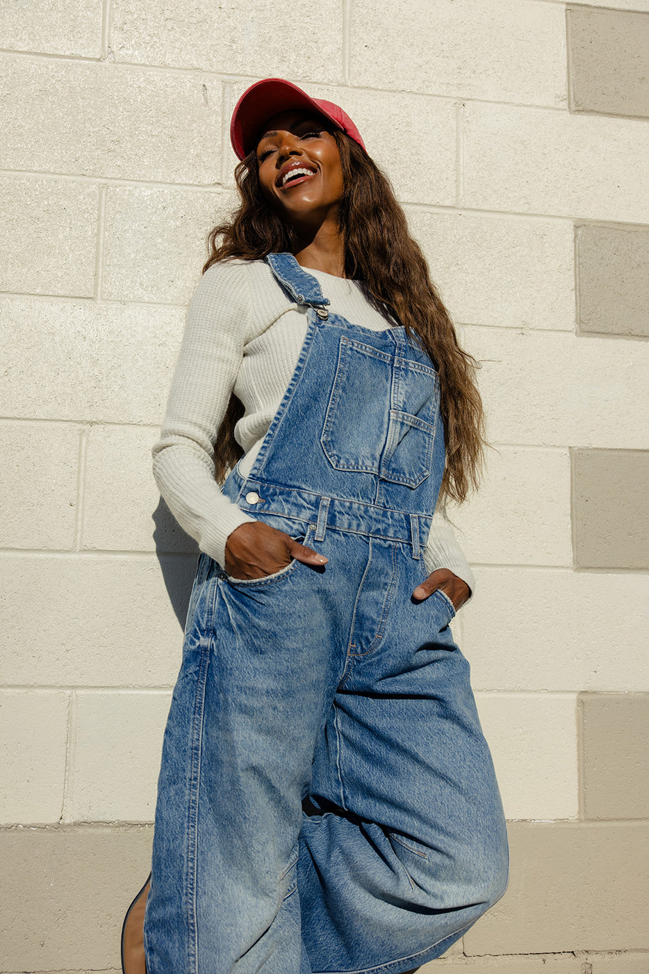 a woman in overalls smiling