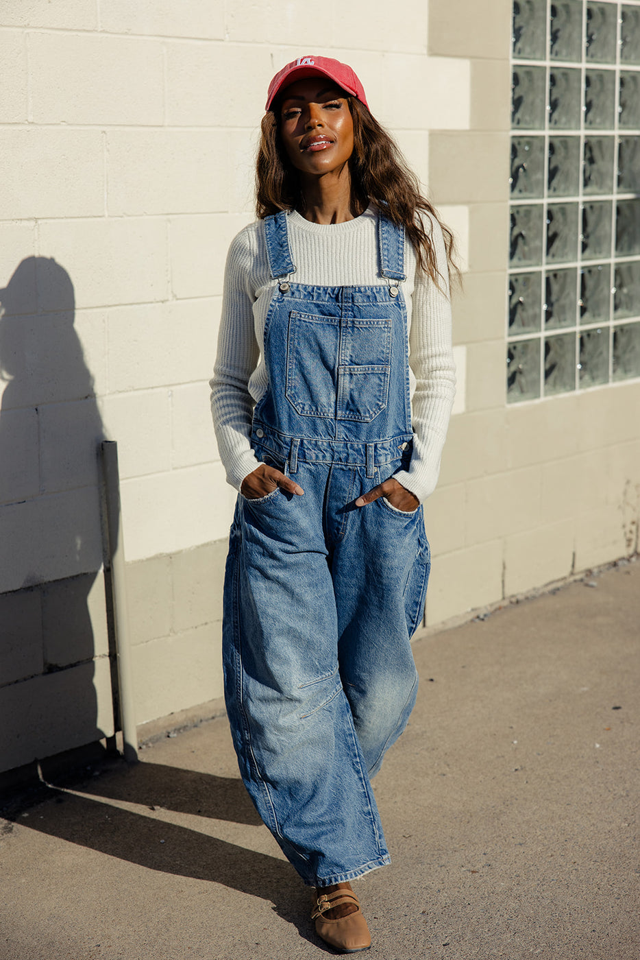 a woman in overalls standing outside