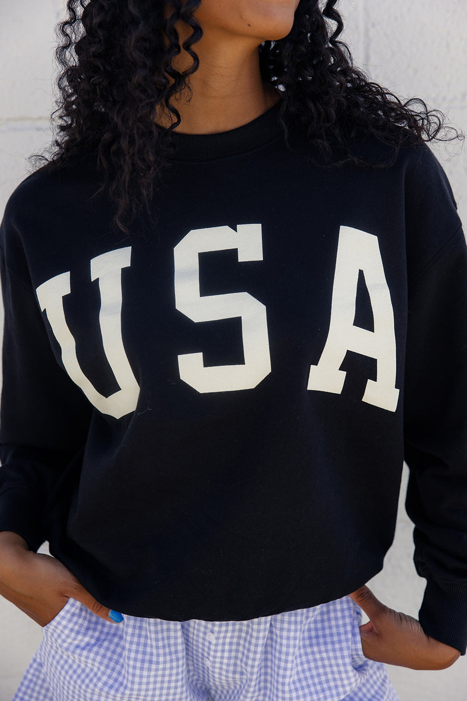 a person wearing a black sweatshirt with white letters on it