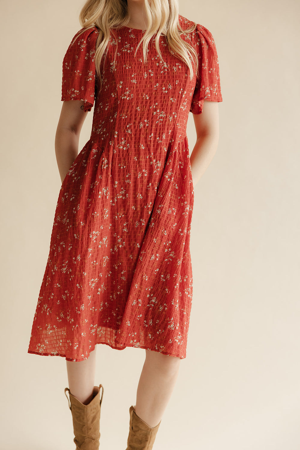 Red floral dress worn by a person on a beige background