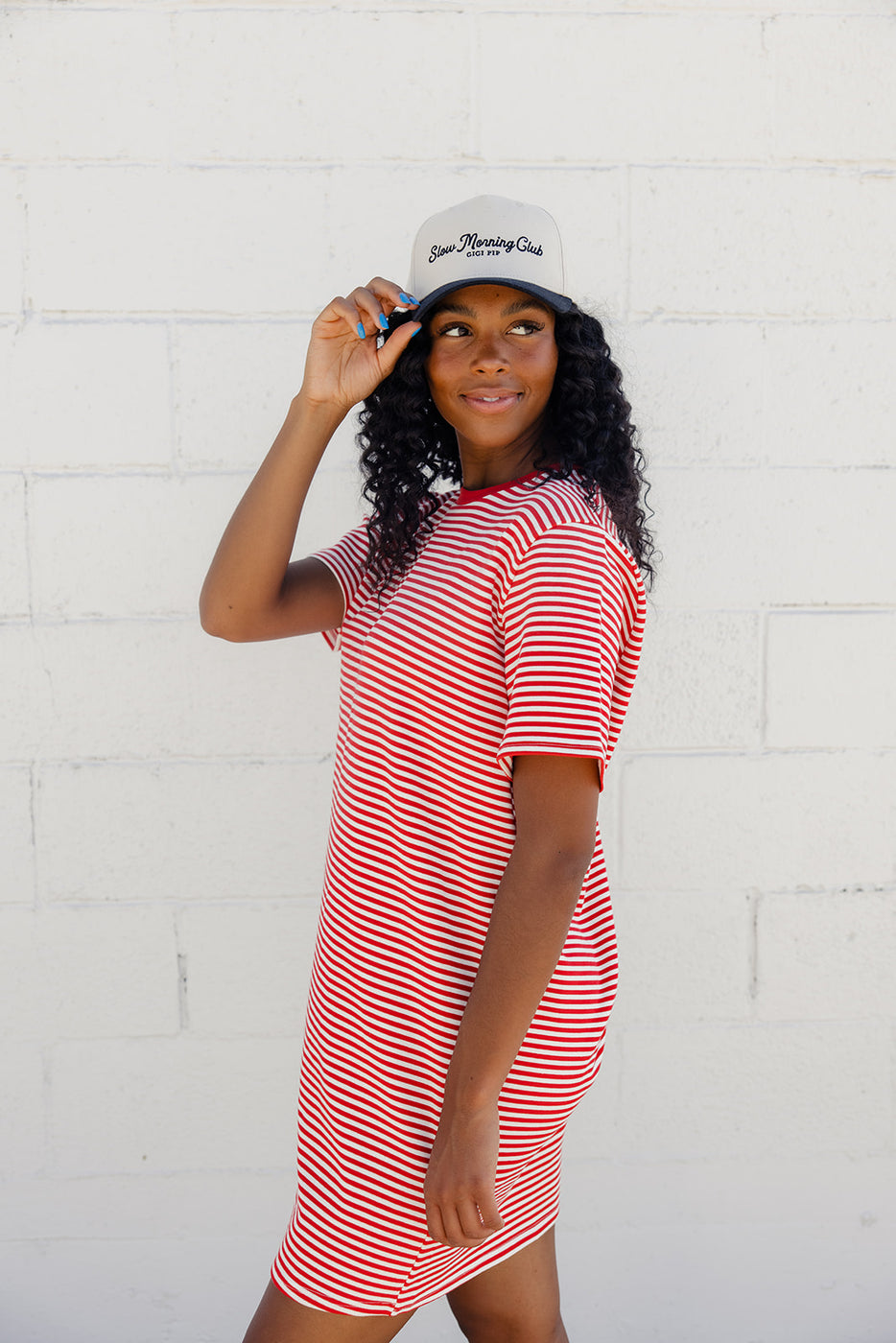 a woman in a red and white striped shirt and white hat