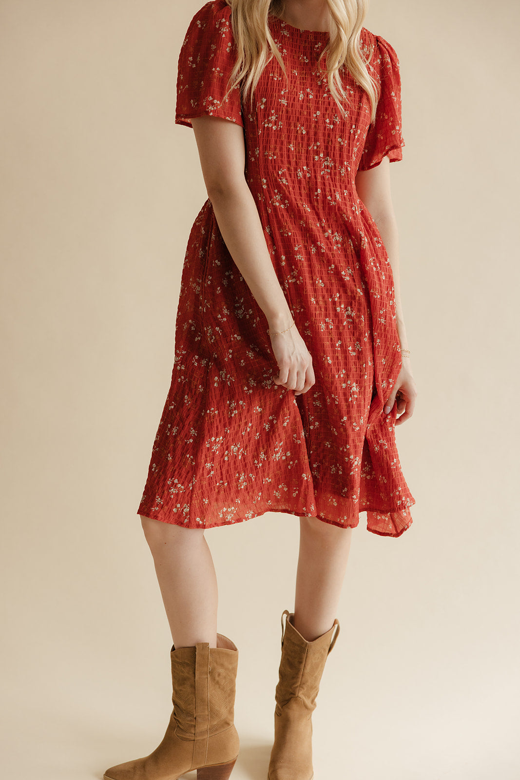 Red floral dress worn by a person on a beige background