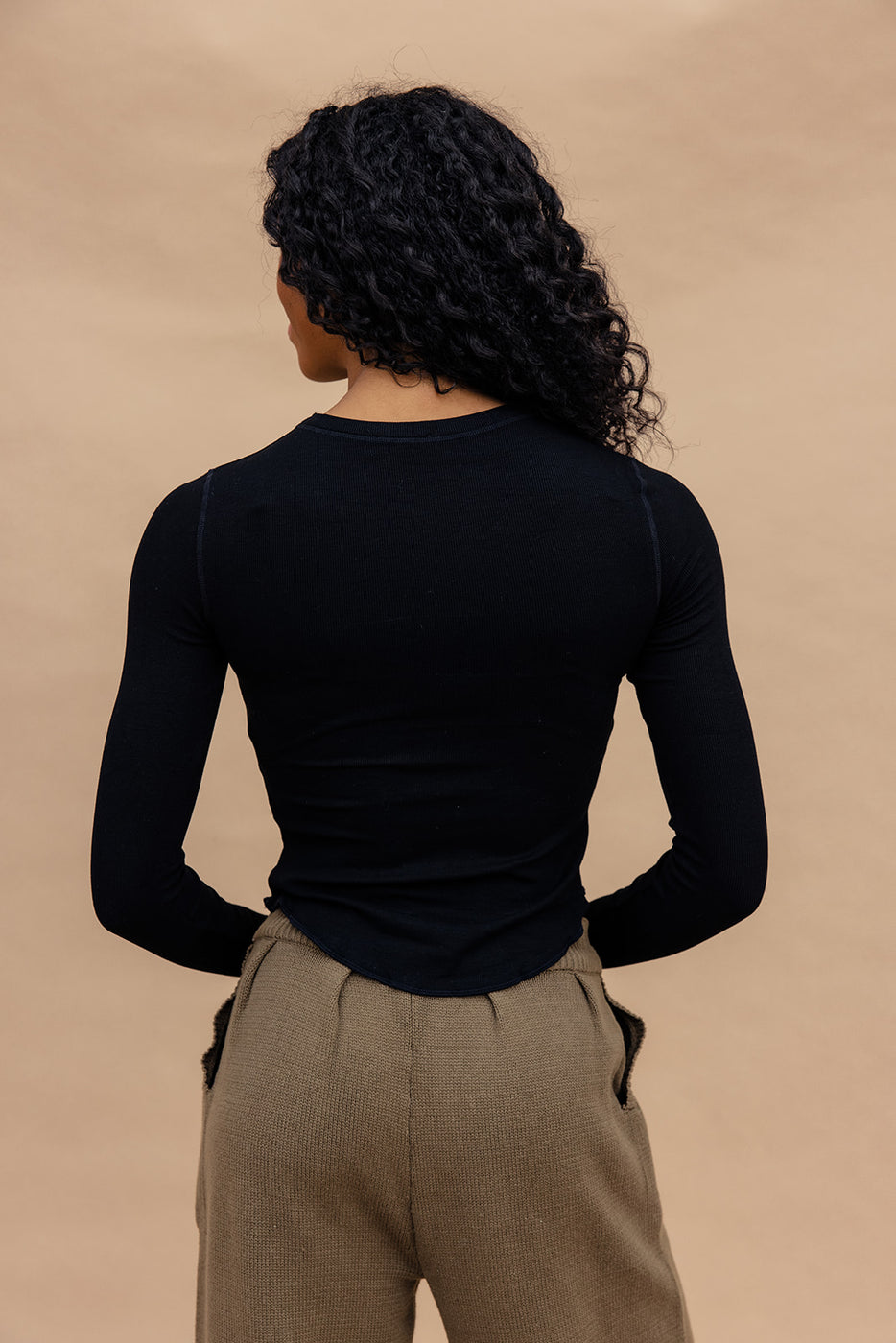 a woman with long curly hair wearing a black shirt