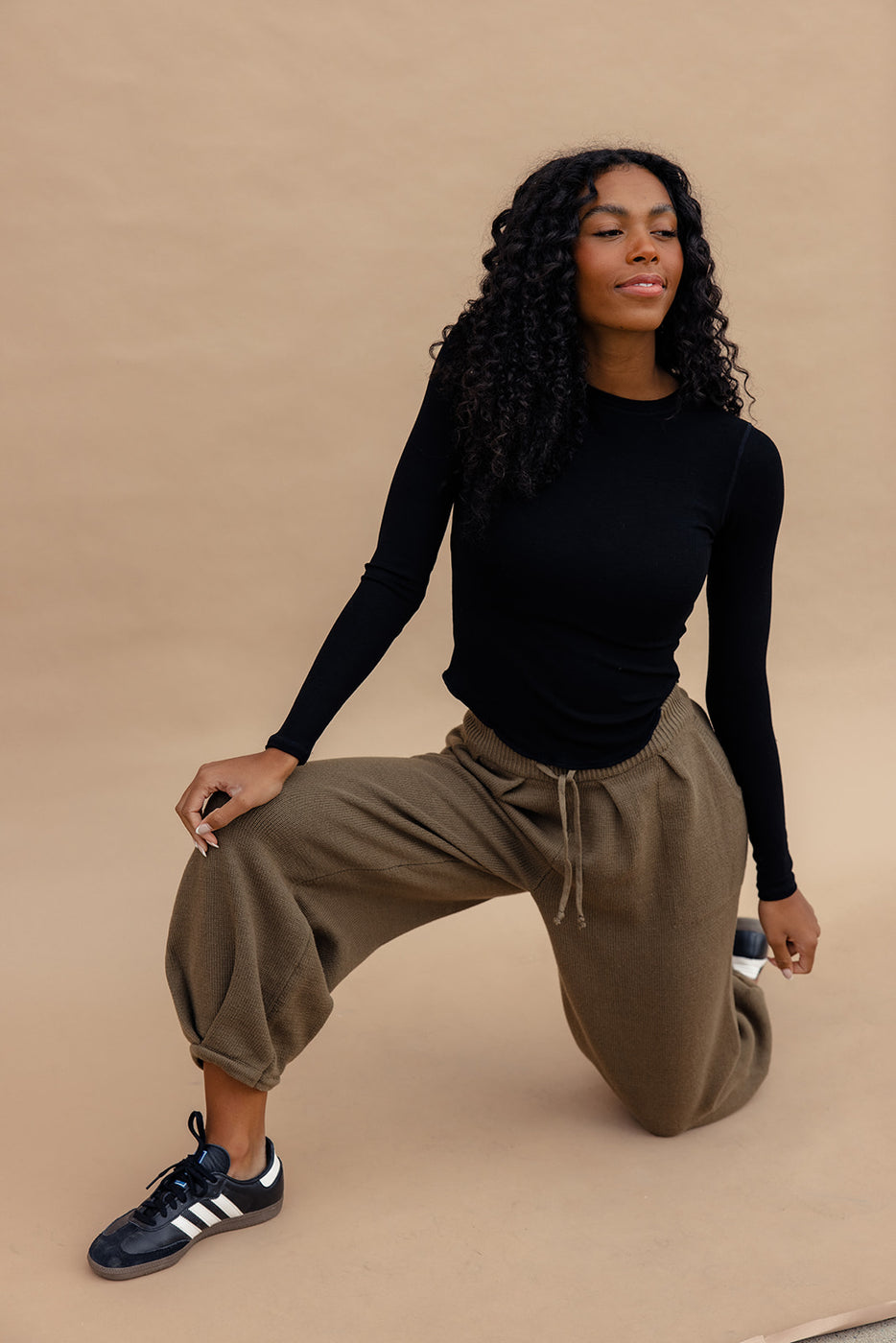 a woman in black shirt and brown pants