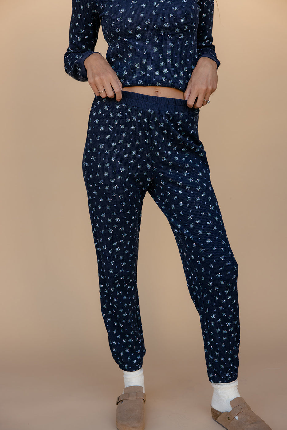 Navy blue pajama set with white patterns on a beige background