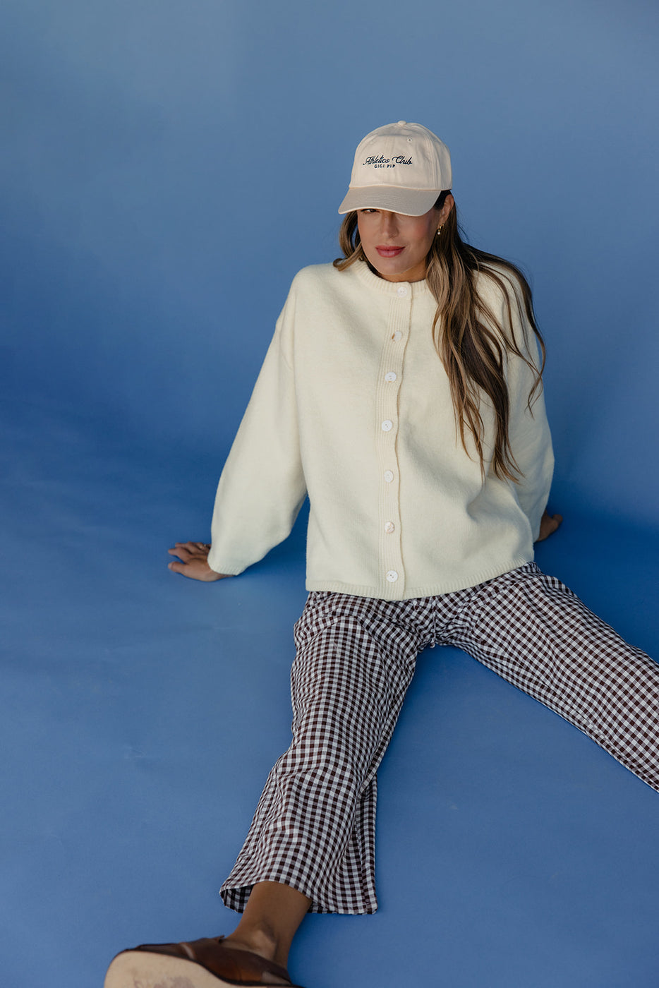 Person wearing a white jacket and checkered pants against a blue background