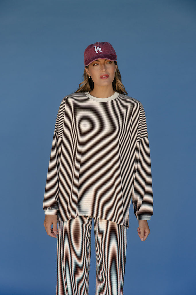 Person wearing a striped outfit and cap against a blue background