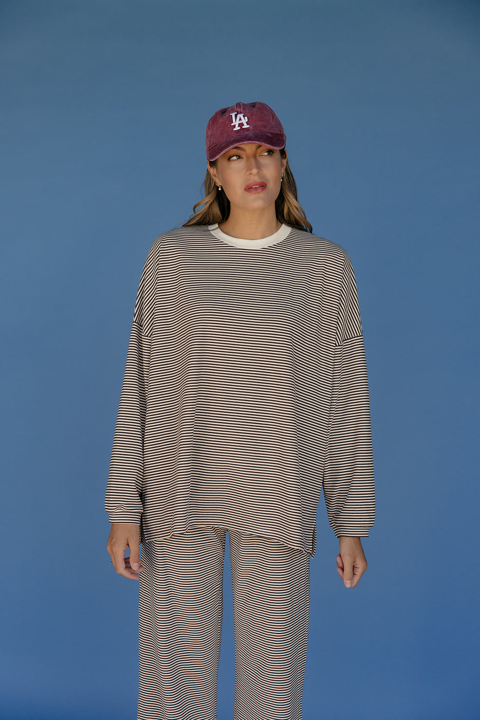 Person wearing a striped outfit and cap against a blue background