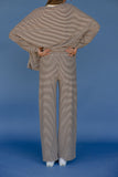 Person wearing a brown and white striped outfit on a blue background
