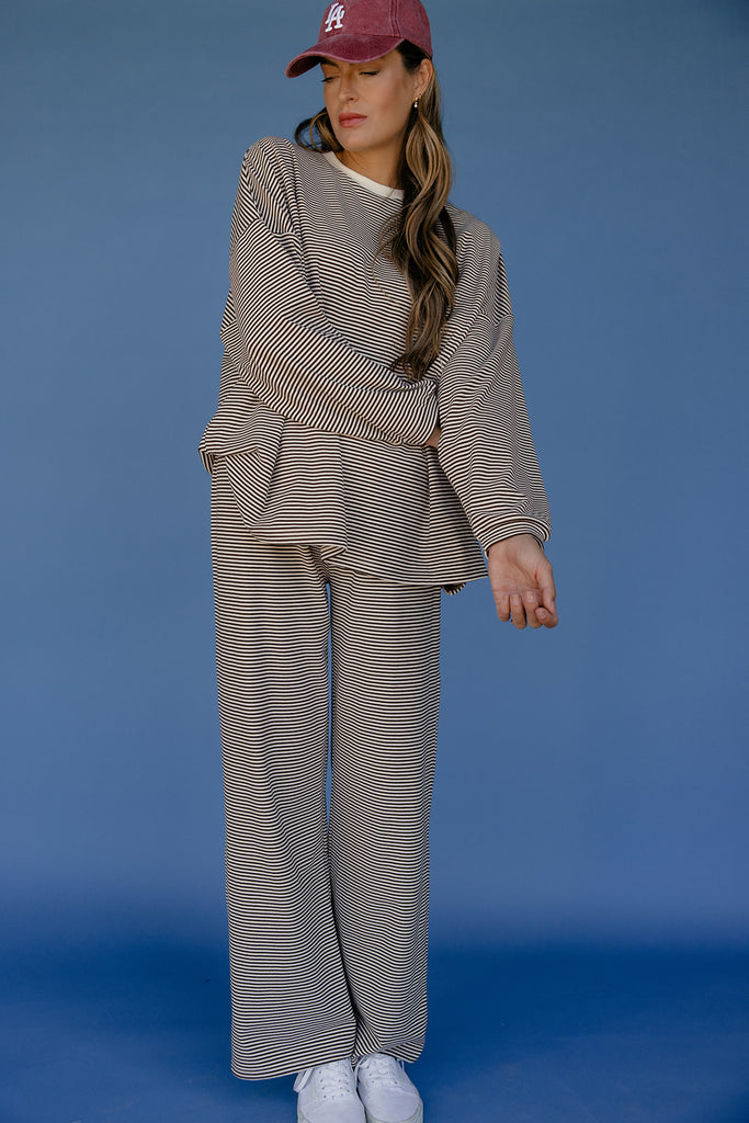 Woman wearing a matching outfit with a red cap against a blue background
