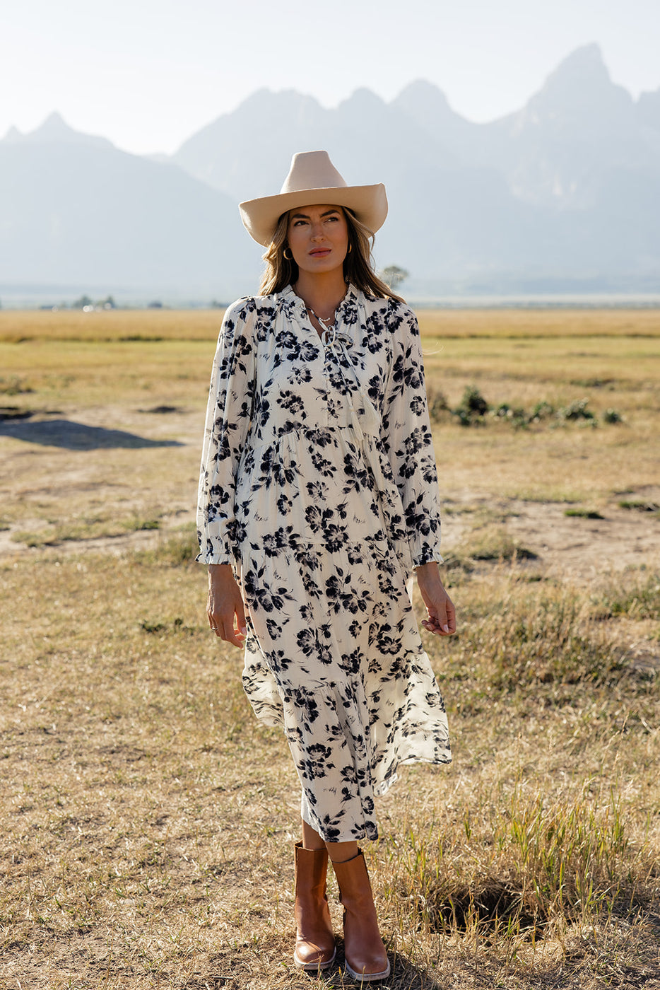 a woman in a long white dress and cowboy hat