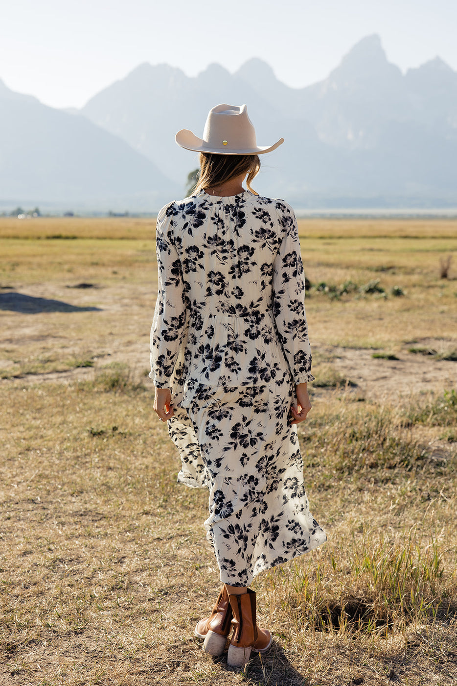 a woman wearing a white hat and a long dress