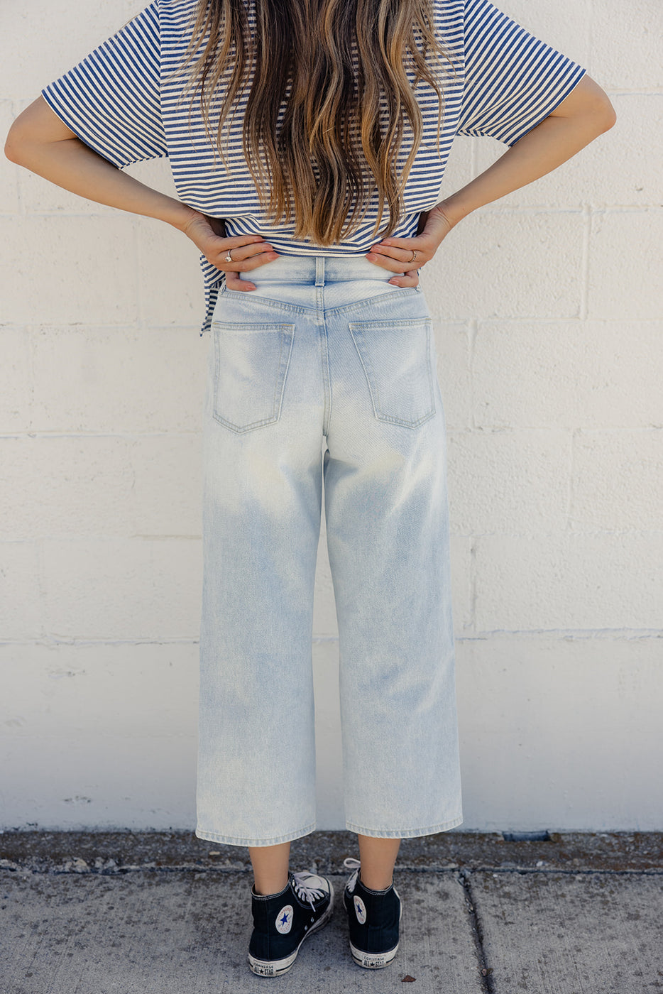 a woman in a striped shirt and blue jeans