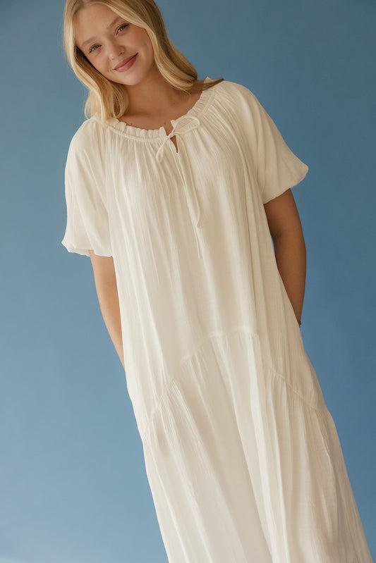 Woman wearing a white dress against a blue background