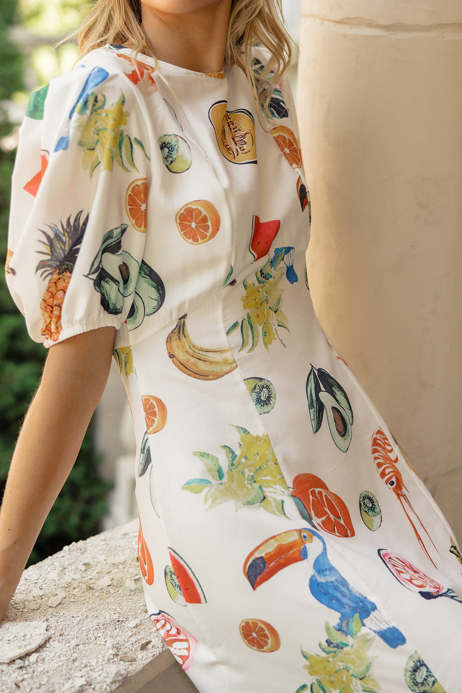 a woman wearing a dress with fruit designs