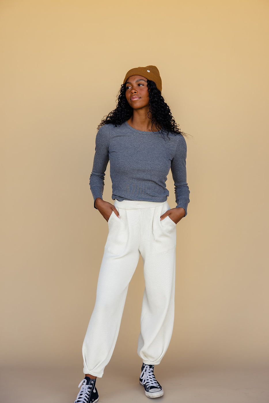 a woman in a hat and white pants