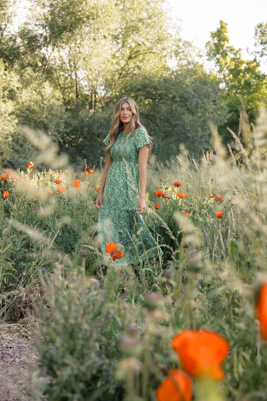 a woman standing in a field of flowers