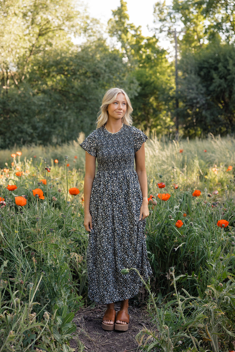 a woman standing in a field of flowers