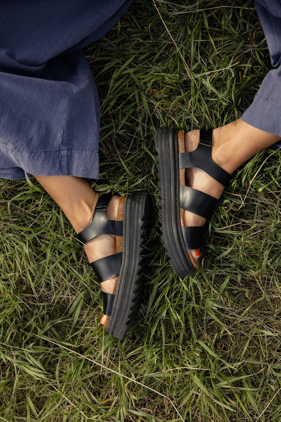 a person's feet in a grass field