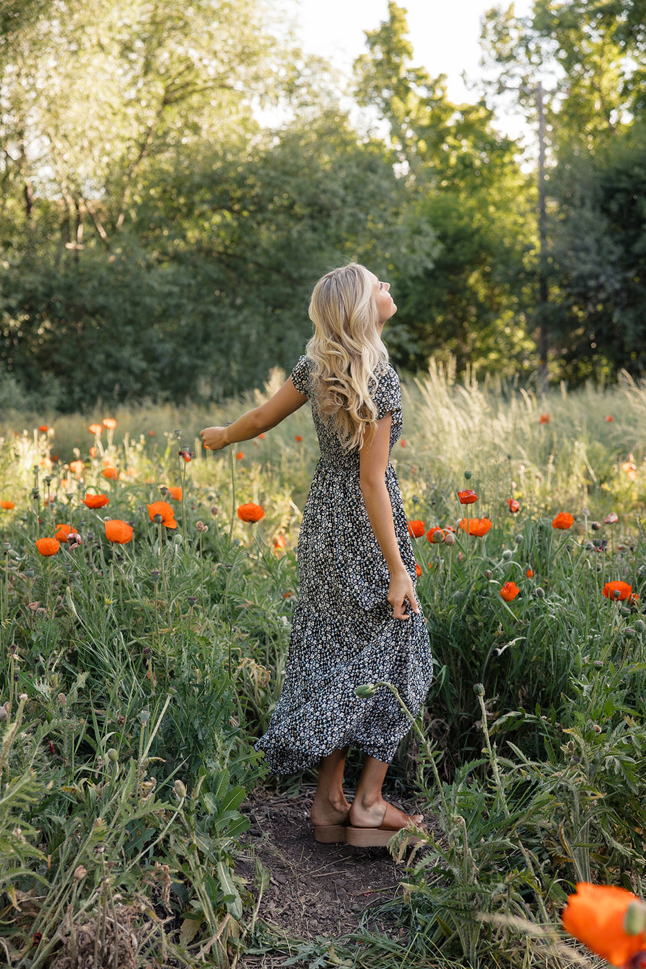 a woman standing in a field of flowers