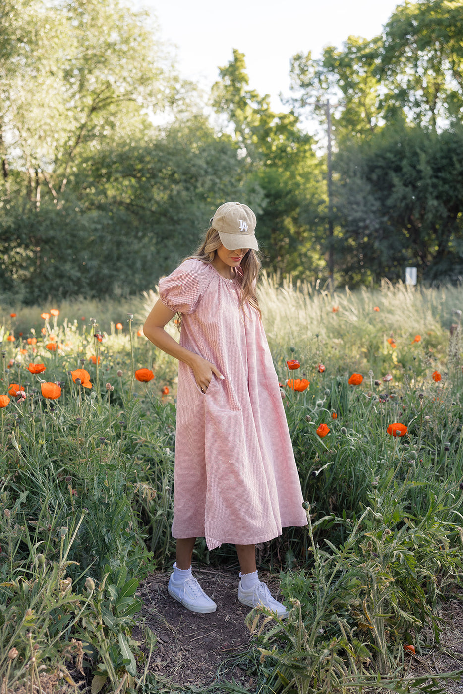 a woman in a pink dress in a field of flowers