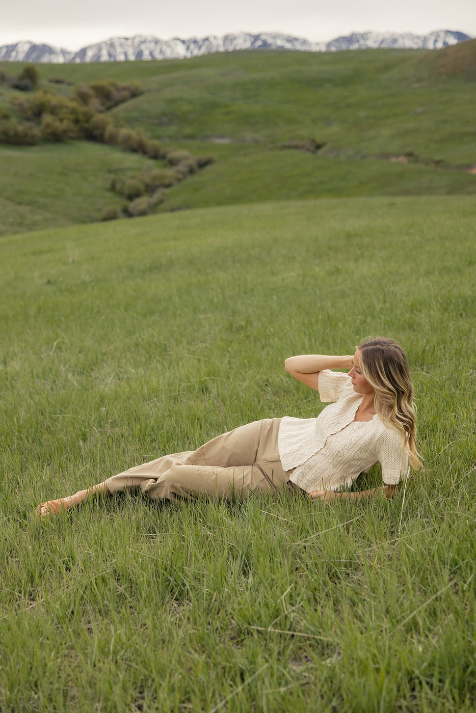a woman lying in a grassy field