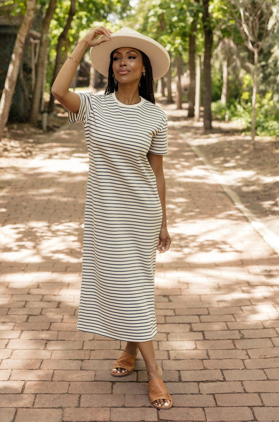 a woman wearing a white hat and dress