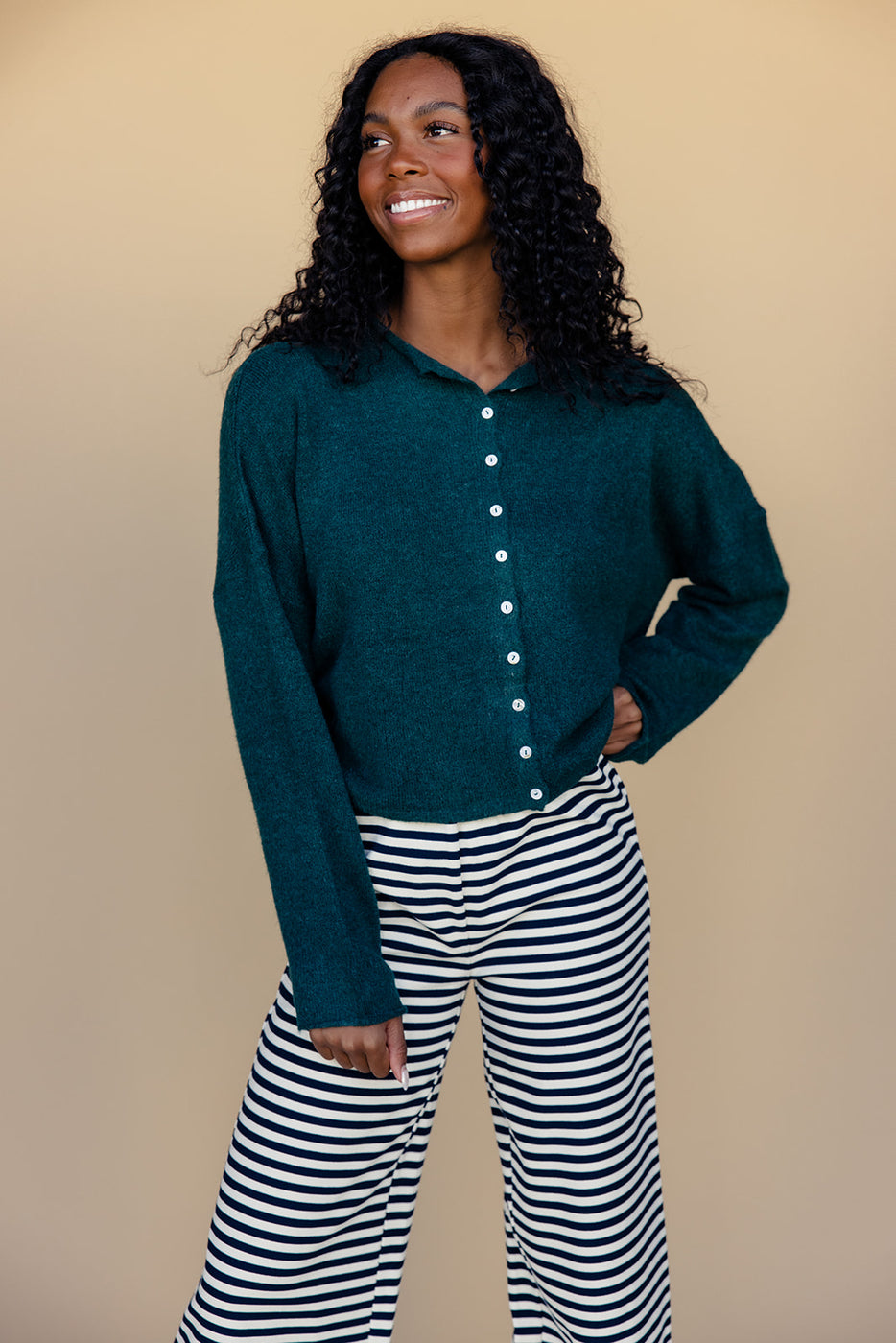 a woman wearing a green shirt and striped pants