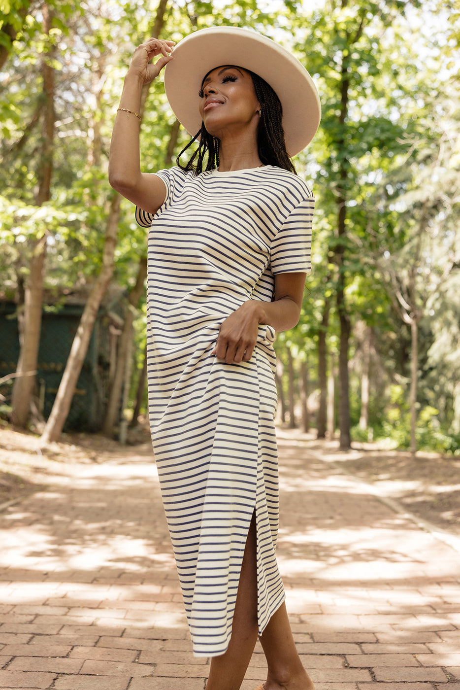 a woman wearing a striped dress and hat