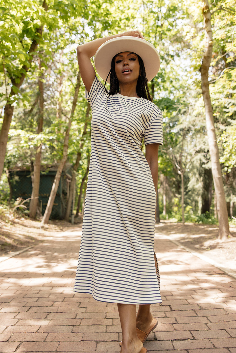 a woman wearing a white hat and striped dress