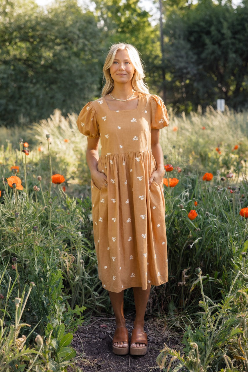 a woman standing in a field of flowers