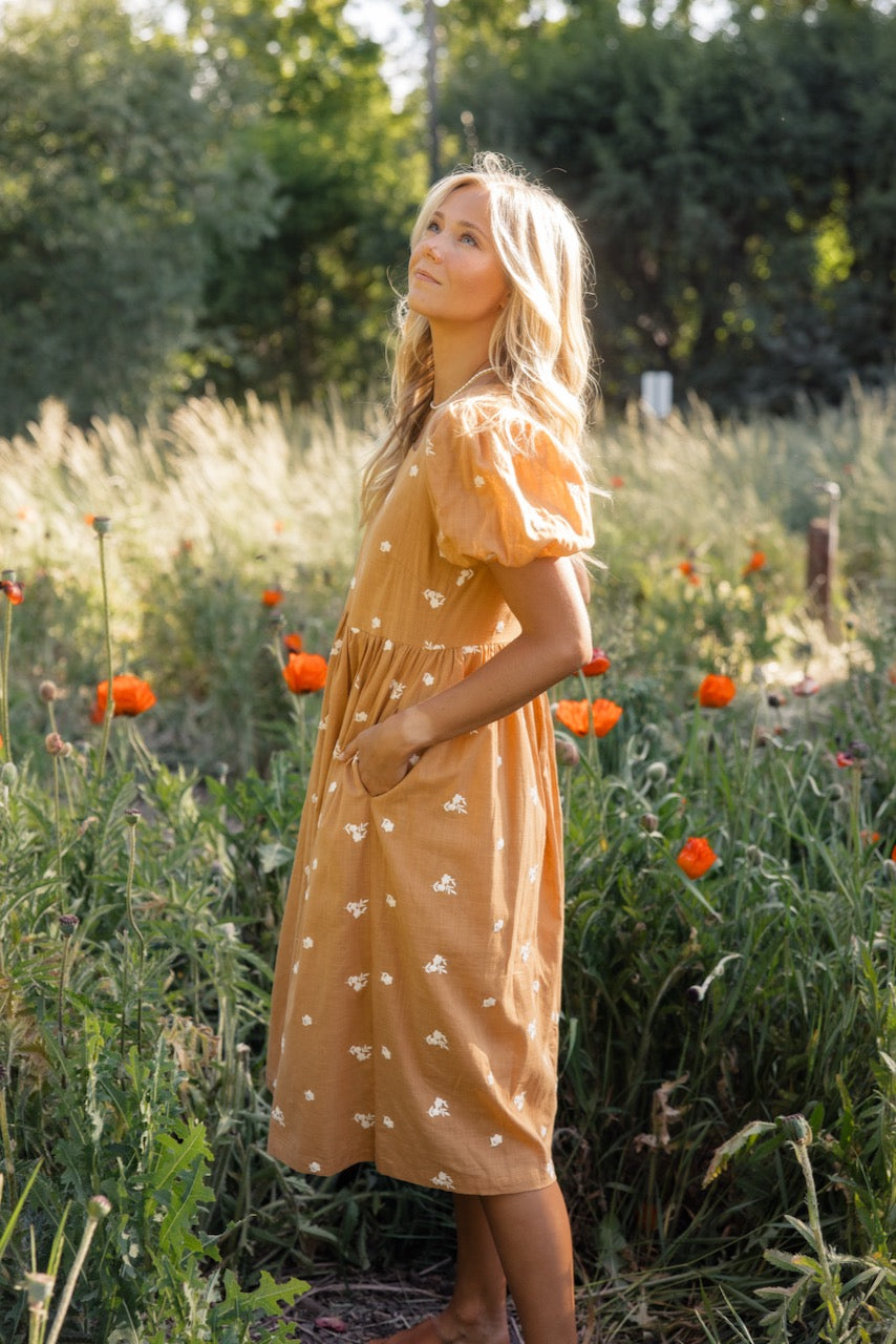 a woman in a dress in a field of flowers