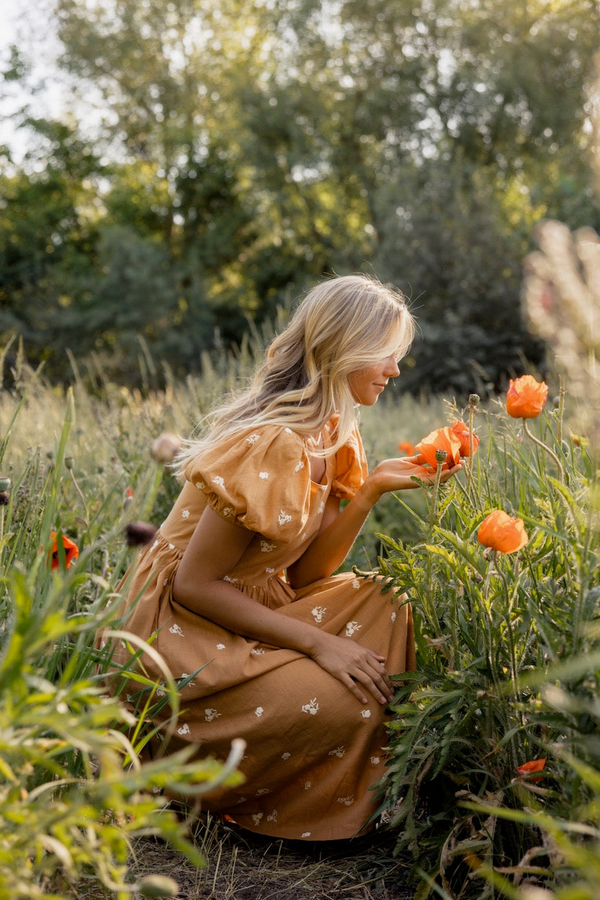 a woman in a dress in a field of flowers