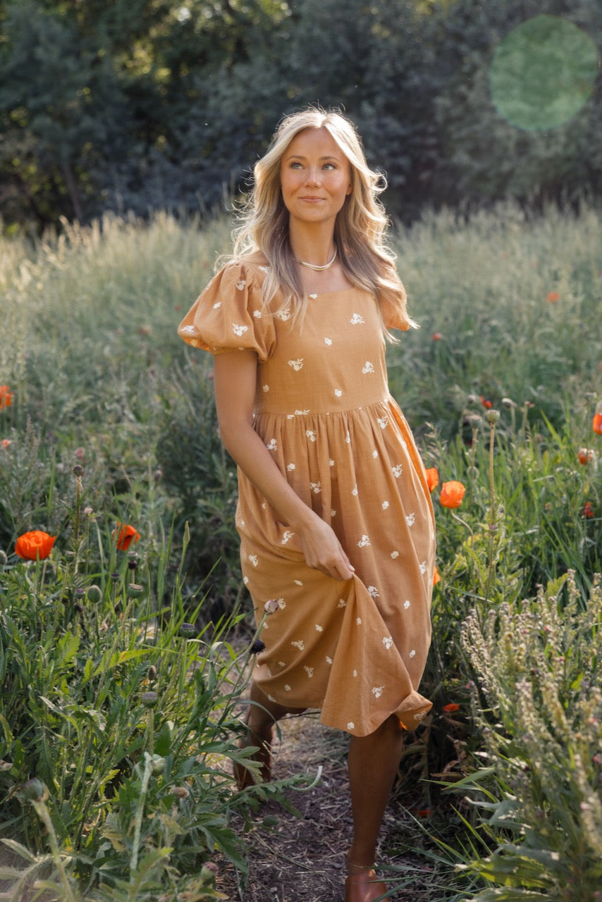 a woman in a dress in a field of flowers